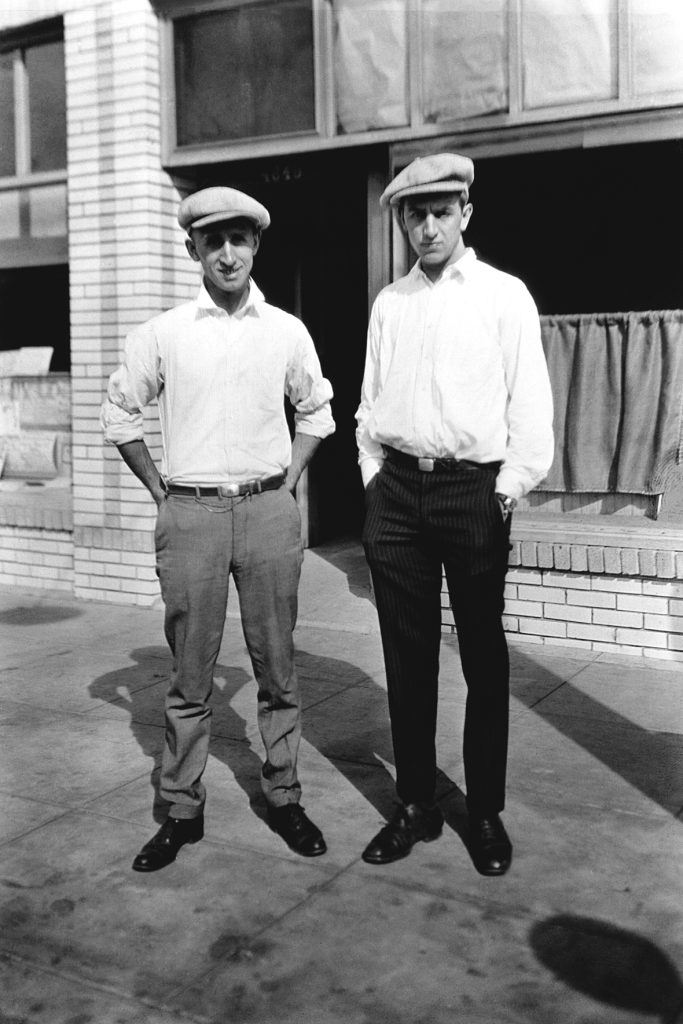 Walt Disney (left) and Roy Disney (right) pose for a photo in matching hats.