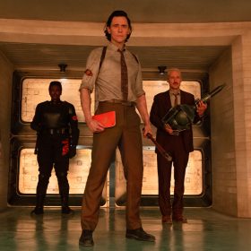 O.B. (Ke Huy Quan), Hunter B-15 (Wunmi Mosaku), Loki (Tom Hiddleston), and Mobius (Owen Wilson) stand in front of a doorway inside the TVA.