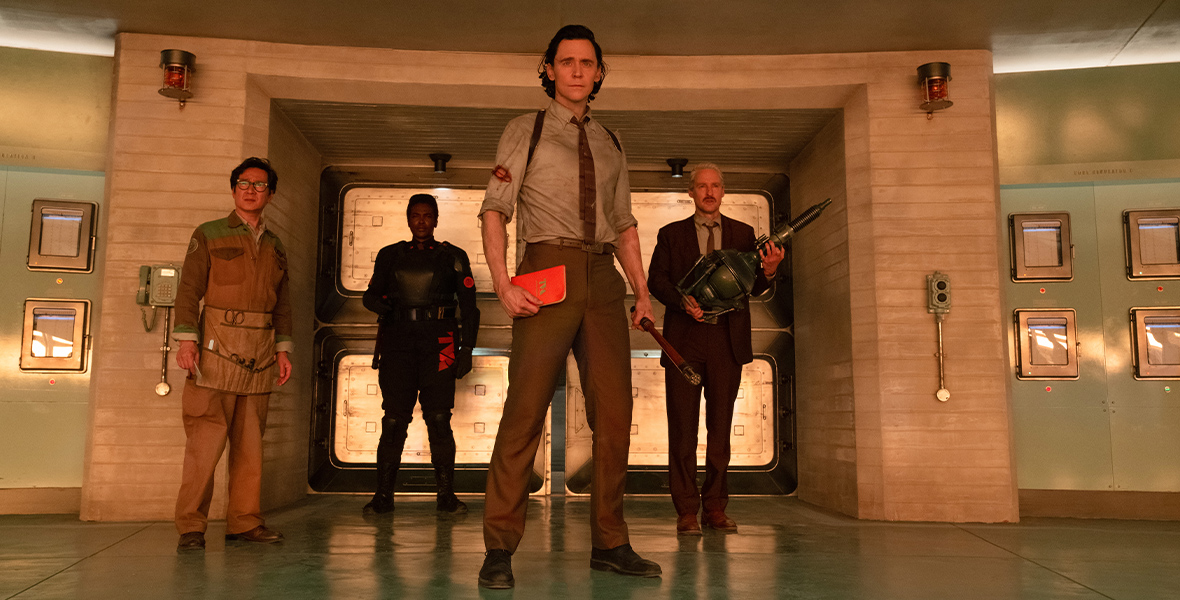 O.B. (Ke Huy Quan), Hunter B-15 (Wunmi Mosaku), Loki (Tom Hiddleston), and Mobius (Owen Wilson) stand in front of a doorway inside the TVA.