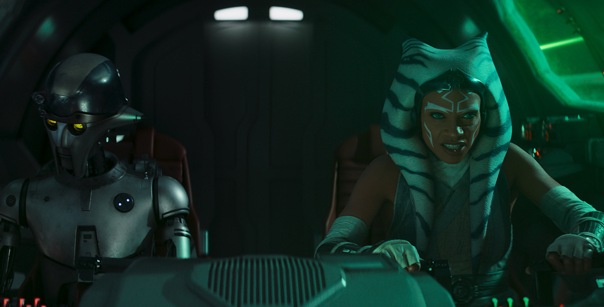 In an image from Star Wars: Ahsoka, Huyang (voiced by David Tennant) and Ahsoka Tano (Rosario Dawson) are seen inside the cockpit of a spaceship. Ahsoka has a determined look on her face as she’s piloting the ship.