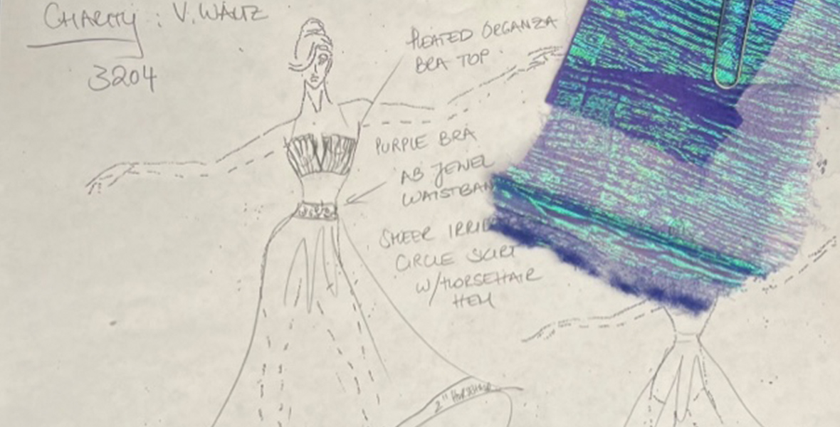 A sketch shows a woman dressed in a top and skirt. The top is cropped with thin straps and the skirt is flowy with a trim at the bottom. A piece of purple blue shimmery fabric is attached to the paper with a paperclip. Arrows point to her with descriptor words of her outfit. 