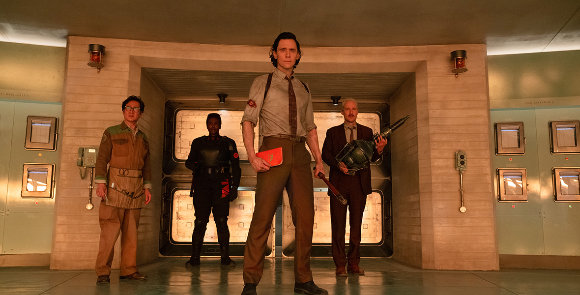 In an image from Marvel Studios’ Loki, from left to right, are Ke Huy Quan as O.B., Wunmi Mosaku as Hunter B-15, Tom Hiddleston as Loki, and Owen Wilson as Mobius.