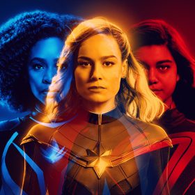 In a poster for The Marvels, Captain Monica Rambeau (Teyonah Parris) appears in blue, Carol Danvers aka Captain Marvel (Brie Larson) appears in yellow, and Kamala Khan aka Ms. Marvel (Iman Vellani) appears in red. The three characters’ photos are overlapping.