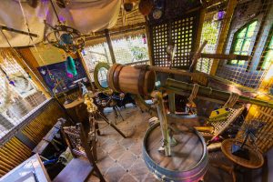 The daughter’s room is stuffed with astronomic paraphernalia. At the center is a large telescope, homemade from a small barrel and a sailor’s telescope. Around it are related objects, including a model of the solar system, a map of the night sky pinned to the wall, and much more.