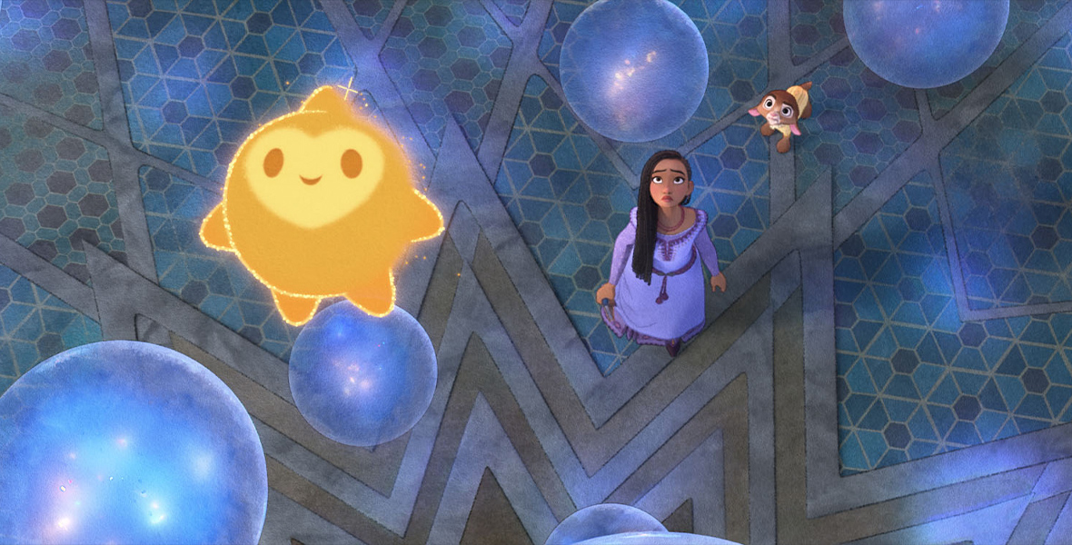 In this still image from Walt Disney Feature Animation’s Wish, the golden orb that is the character Star floats in the foreground, surrounded by glowing blue globes that represent the wishes of the people of Rosas. Behind and far below Star, standing on a tiled floor, are Asha and Valentino.