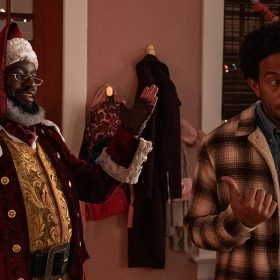 Nick, played by Lil Rel Howery, and Eddie, played by Chris Bridges aka Ludacris stand next to each other. Nick is in a Santa suit and has his arms up while smiling. Eddie has a blank look on his face as he looks away from Nick while pointing at him.