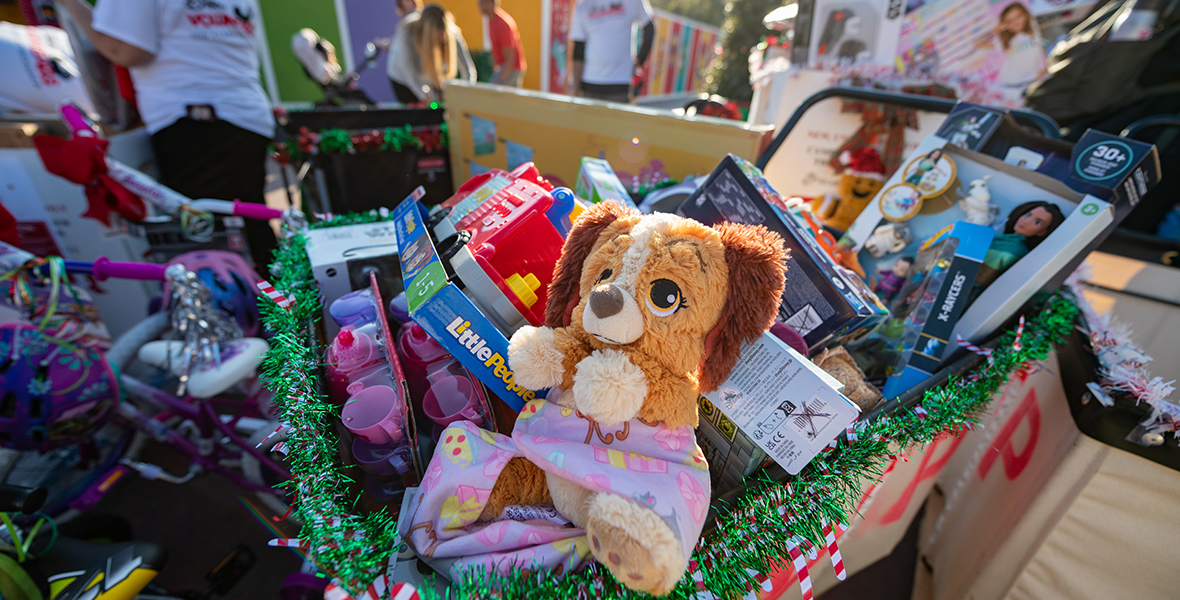 Disney toys are piled on top of each other in a Toys for Tots donation box.