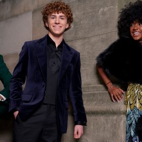 In an image from the world premiere for Disney+’s Percy Jackson and the Olympians, from left to right, Aryan Simhadri (Grover Underwood), Walker Scobell (Percy Jackson), and Leah Sava Jeffries (Annabeth Chase) are dressed to impress at the Metropolitan Museum of Art in New York City. Simhadri and Scobell look at the camera while Jeffries looks off to the left.
