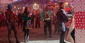 In an image from the Marvel Studios&rsquo; Special Presentation The Guardians of the Galaxy Holiday Special, from left to right, Karen Gillan as Nebula, Pom Klementieff as Mantis, Dave Bautista as Drax, and Chris Pratt as Peter Quill/Star-Lord are standing in the middle of Knowhere as Peter begins unwrapping a huge gift. Mantis and Drax are wearing ugly Christmas sweaters, and Christmas lights are strewn every which way.