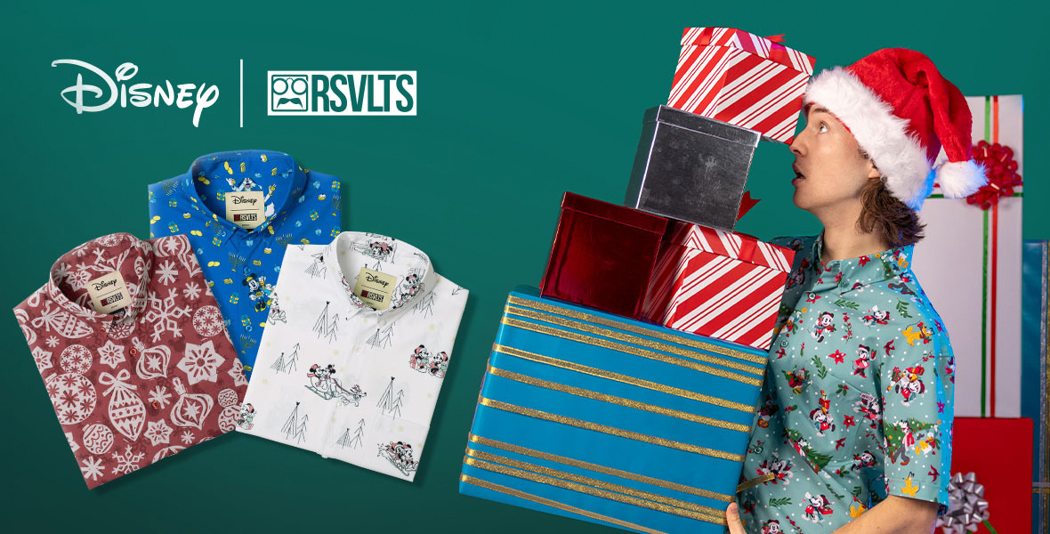 At left in profile is a man with Santa hat on and a holiday RSVTS short-sheeve shirt. He holds several wrapped presents precariously. At left are three RSVTS shirts with holiday-inspired prints. The logo Disney| RSVTS at top.