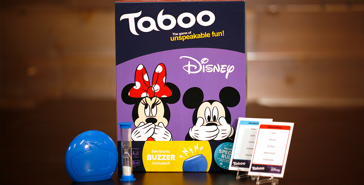 The Disney branded TABOO game box sits at center, with playing card, sand timer and other game objects in front. 