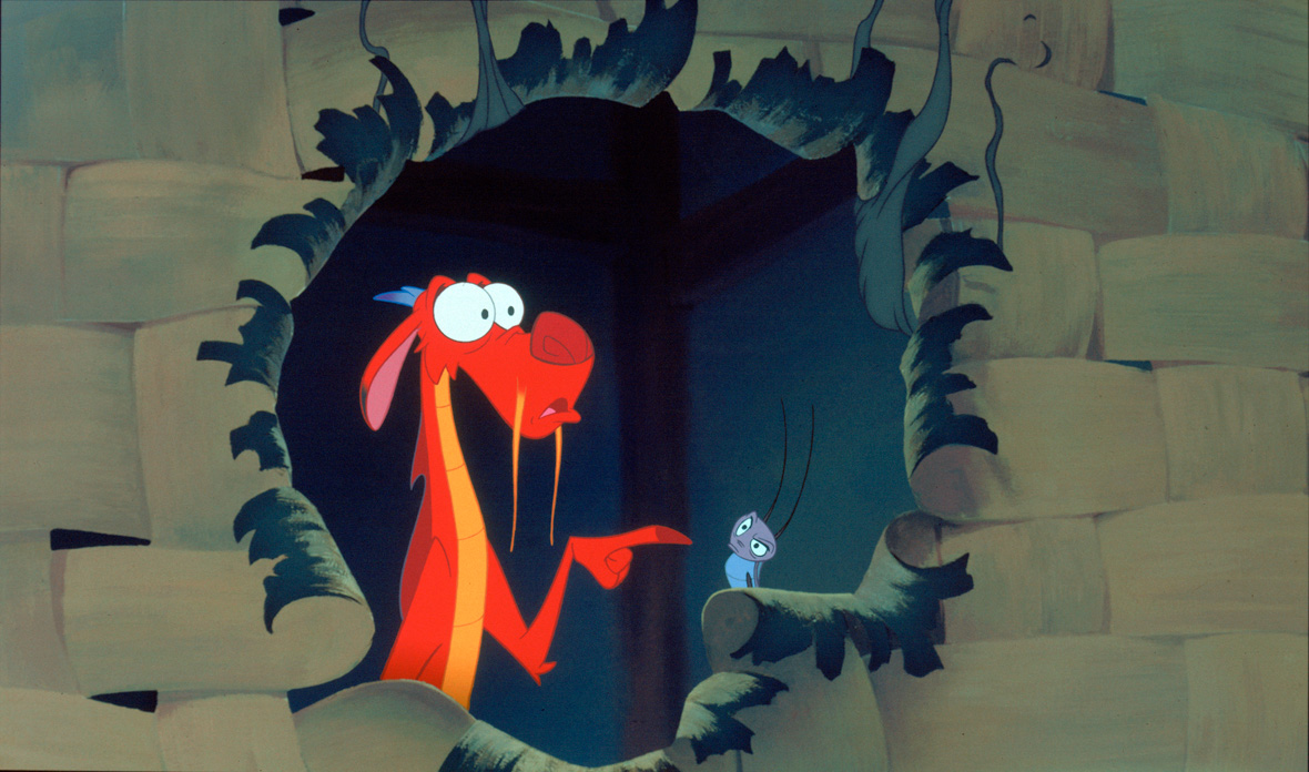 Mushu and Cri-Kee are standing inside a woven surface that has been partially destroyed. Mushu has a scared and startled expression on his face, pointing to perhaps what caused the blow, while Cri-Kee looks at Mushu with confusion and slight anger.
