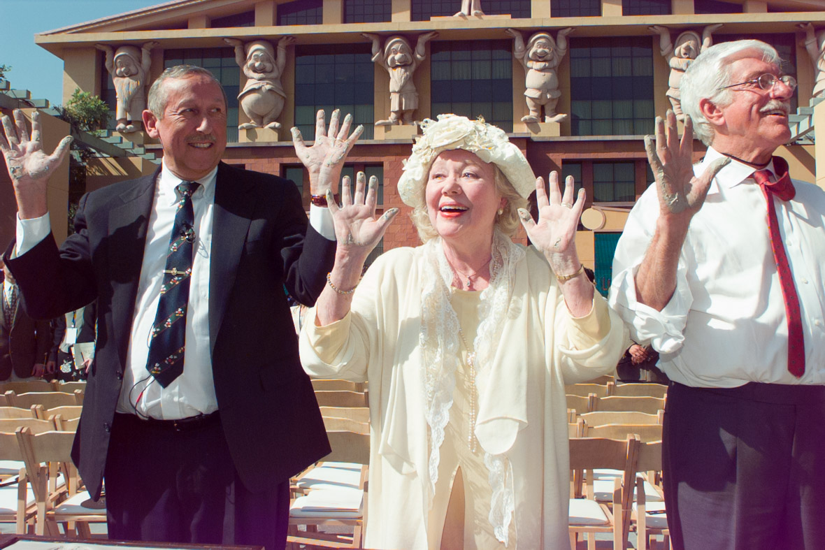 Roy E. Disney (left), Glynis Johns (center), and Dick Van Dyke (right) raise their cement-covered hands during the Disney Legends induction ceremony in Burbank in 1998.
