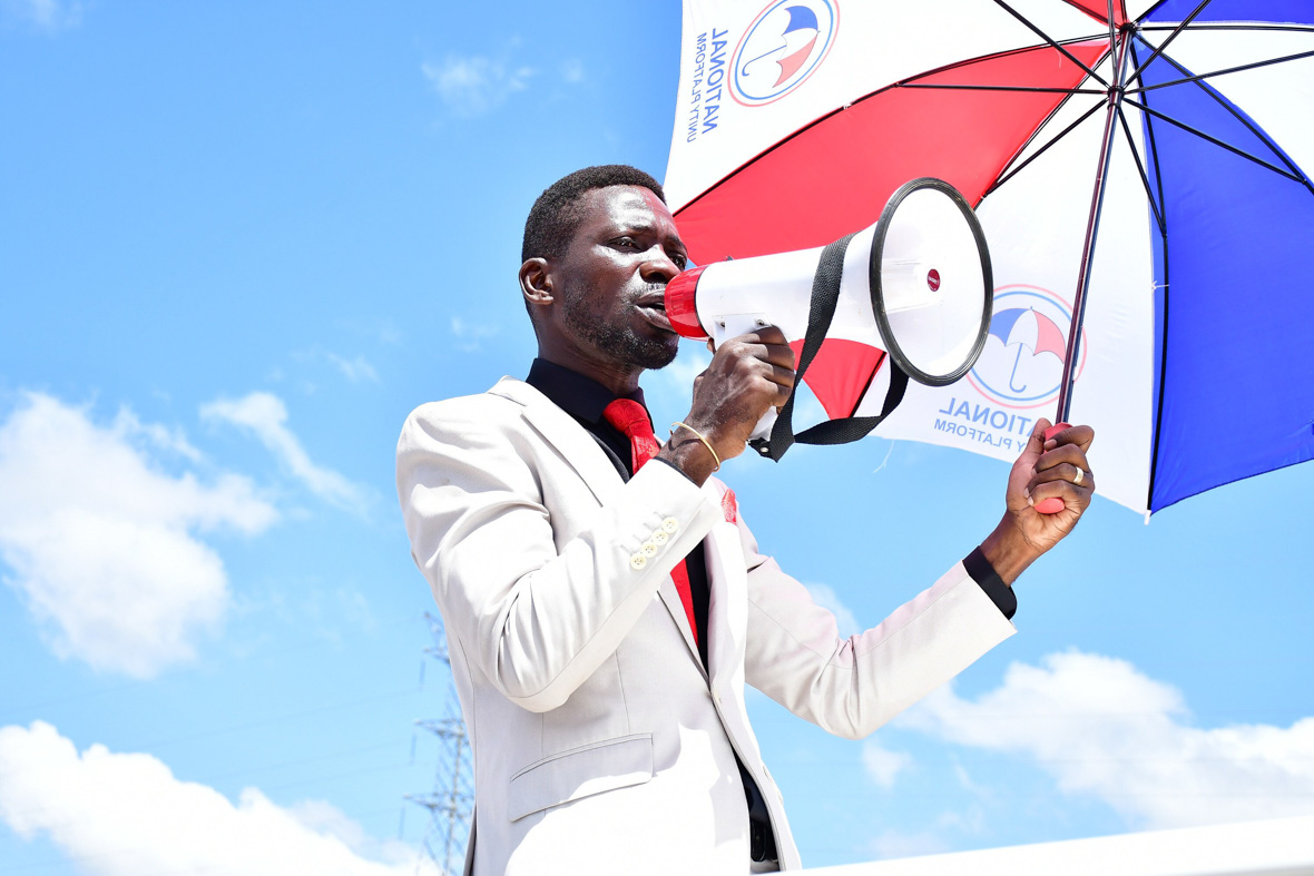 In a scene from National Geographic Documentary Films' Bobi Wine: The People's President, musician and politician Robert Kyagulanyi Ssentamu, aka Bobi Wine, holds a megaphone in one hand and holds an umbrella in the other to shield himself from the sun.