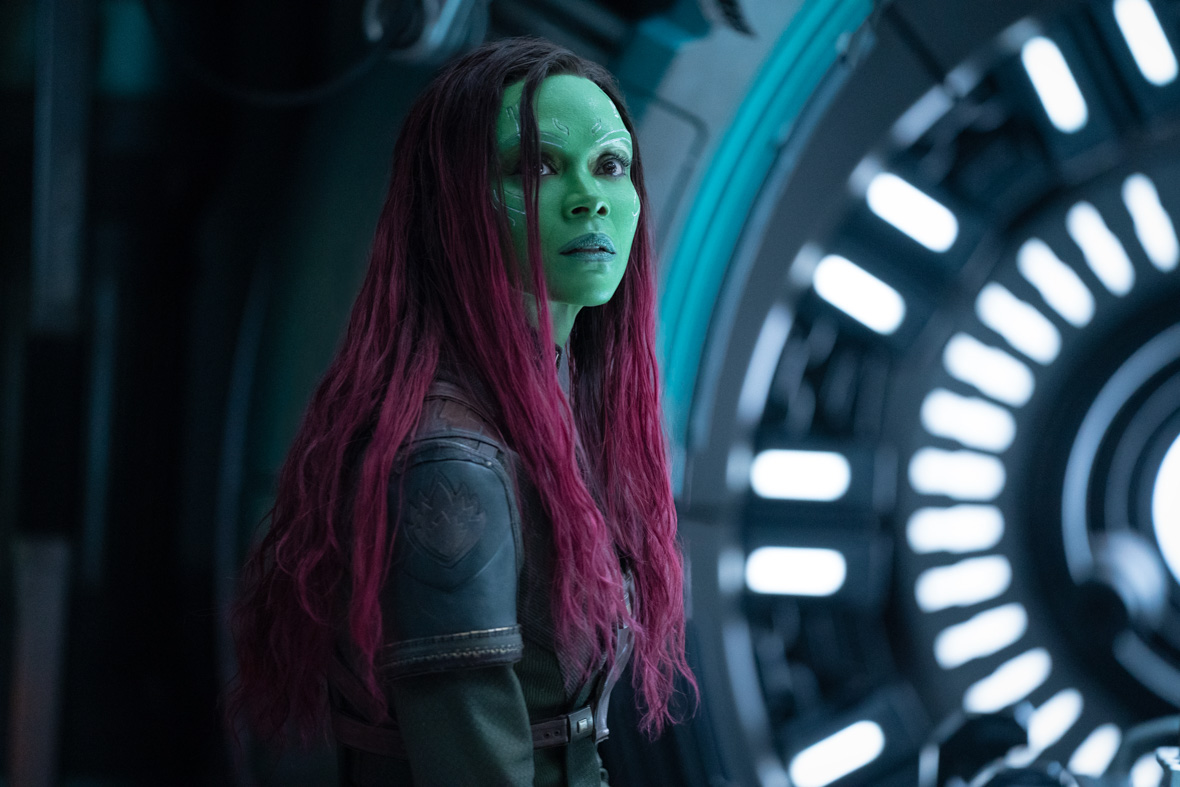 In a scene from Marvel Studios' Guardians of the Galaxy Vol. 3, the green-skinned, purple-haired Ravager known as Gamora, played by Zoe Saldaña, stands inside a spaceship.