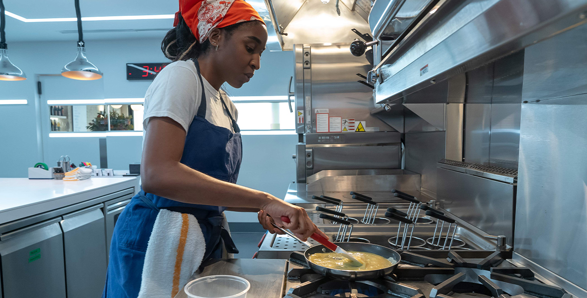 Sous-chef Sydney Adamu, played Ayo Edibiri, makes an omelet in FX's The Bear.