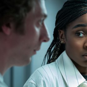 In a scene from The Bear, a seemingly concerned Sydney Adamu, played by Ayo Edebiri, looks at an out-of-focus Carmen "Carmy" Berzatto, played by Jeremy Allen White.