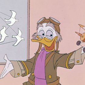 Professor Ludwig Von Drake, an animated duck character, wears an old-fashioned aviator costume of tan shirt, brown jacket with gold trim and buttons, lavender scarf, and, on the top of his head, goggles. He appears to be speaking, with his right hand extended and his left hand holding a model of a biplane with a spinning propellor. Ludwig is looking at the airplane model. A globe is partially visible on the right and there’s a framed image of a hot-air balloon with a solo pilot in an attached basket on the wall behind him.