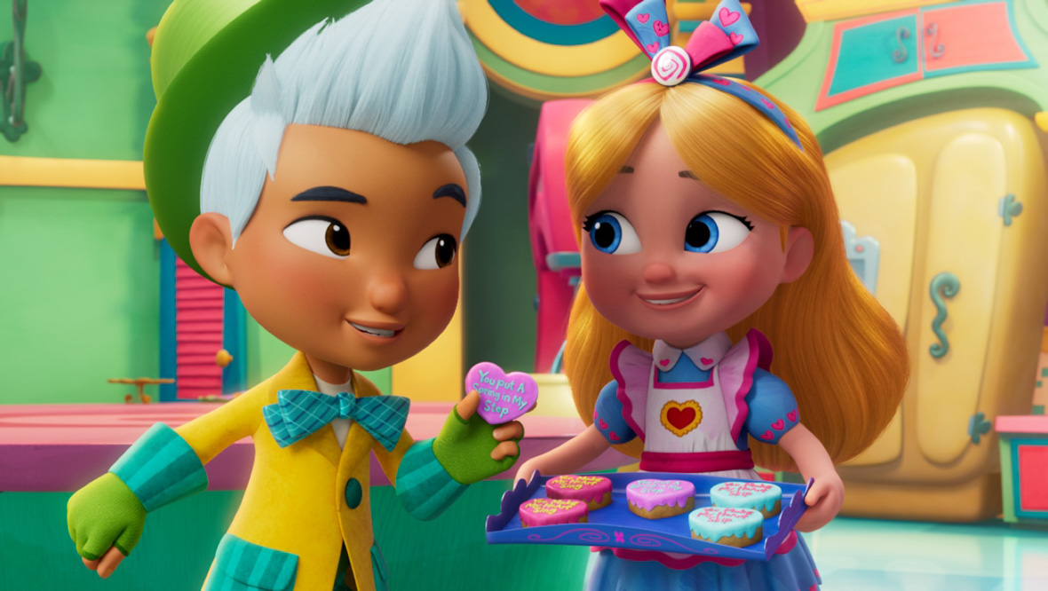 Alice (right), the great-granddaughter of the original Alice Pleasance Lidell, is wearing a blue short-sleeve petticoat dress adorned with pink hearts. She wears a white apron on top and sports a blue headband with pink hearts. Holding a blue tray with heart-shaped cookies, she stands in her bakery, which is colorful. Next to Alice, and looking at her, is Hattie (left), a "mad hatter" boy who is dressed in a yellow coat embellished with green pockets and a bow, topped with a green hat.