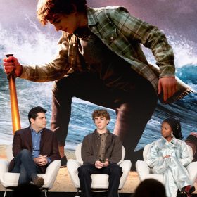 From left to right: Jonathan E. Steinberg, Dan Shotz, Walker Scobell, Leah Sava Jeffries, and Aryan Simhadri sit on a Percy Jackson and the Olympians panel during the Television Critics Association's Winter Press Tour. The series' key art is displayed onscreen behind them, which shows Scobell as Percy Jackson, wielding a sword and parting the sea.