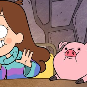 In a scene from Gravity Falls, Mabel Pines and Waddles, her pet pig, sit on a wooden table, both looking excitedly at something in front of them. Mabel is wearing a blue and pink turtleneck sweater and is smiling widely with her palms lifted.