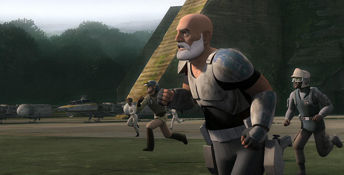 Captain Rex from Star Wars Rebels is depicted in standard gray clone trooper armor, leading a group of characters in a sprint towards an unknown target. The backdrop showcases pyramid-like monuments and airplanes.