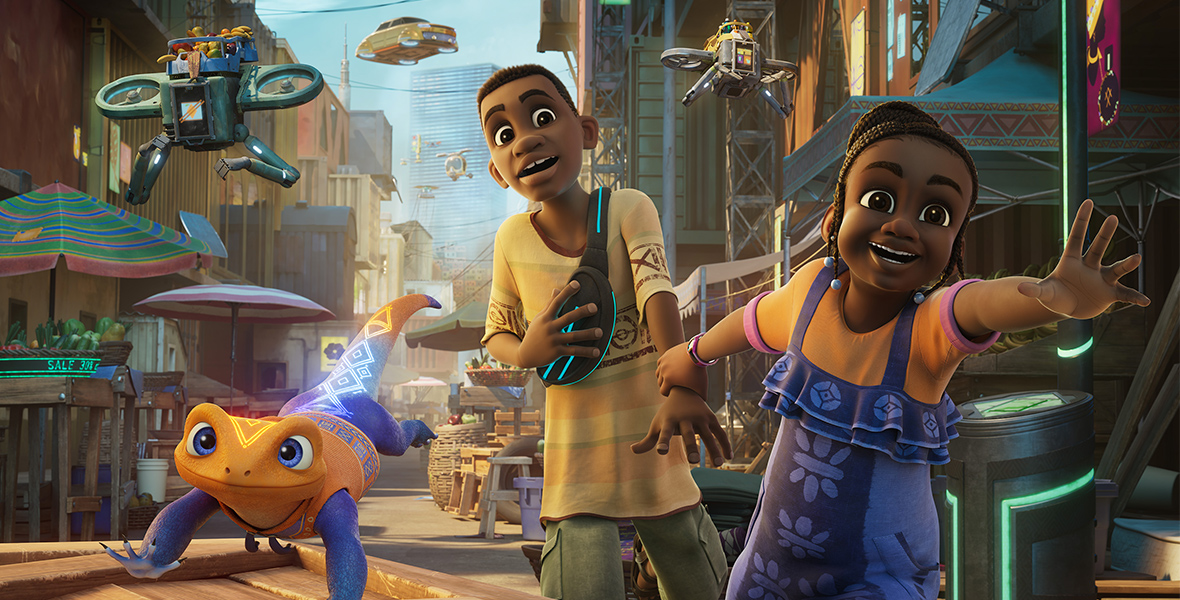 In a scene from the show Iwájú set in Lagos, Nigeria, children Tola and Kole are running through an outdoor market. Tola wears an orange T-shirt with purple overalls, while Kole dons a yellow T-shirt with orange, brown, and green detailing, paired with green cargo shorts, sandals, and a black fanny pack adorned with neon blue strips. Accompanying them is Otin, a purple and orange robotic pet lizard. In the backdrop, towering buildings loom over hovering vehicles.