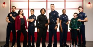 From left to right, Oliver Stark, Jennifer Love Hewitt, Kenneth Choi, Angela Bassett, Peter Krause, Aisha Hinds, Gavin Mchugh, and Ryan Guzman pose for a 9-1-1 cast portrait.