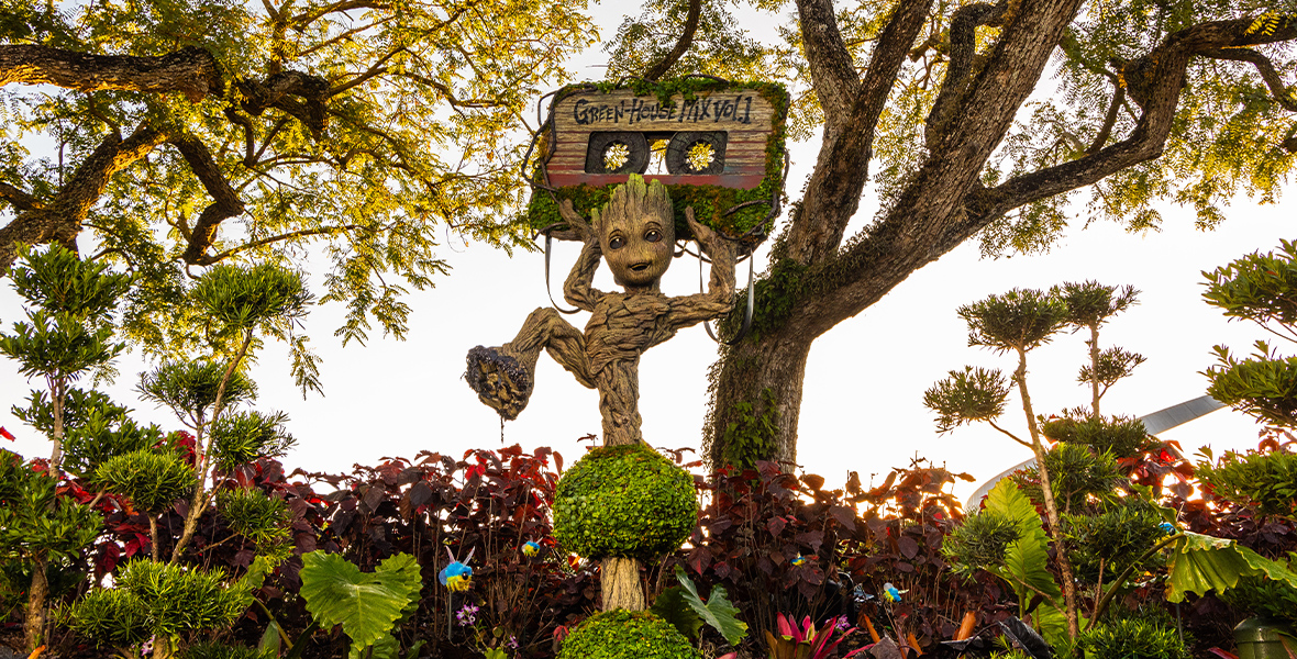 A Horizontal image of the new Groot topiary at EPCOT, surrounded by many plants.