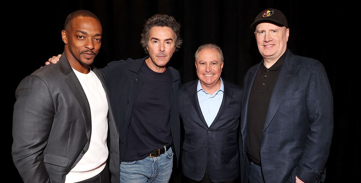 Anthony Mackie, Shawn Levy, Alan Bergman, Co-Chairman, Disney Entertainment, and Kevin Feige, President, Marvel Studios stand together for a group photo against a black backdrop.