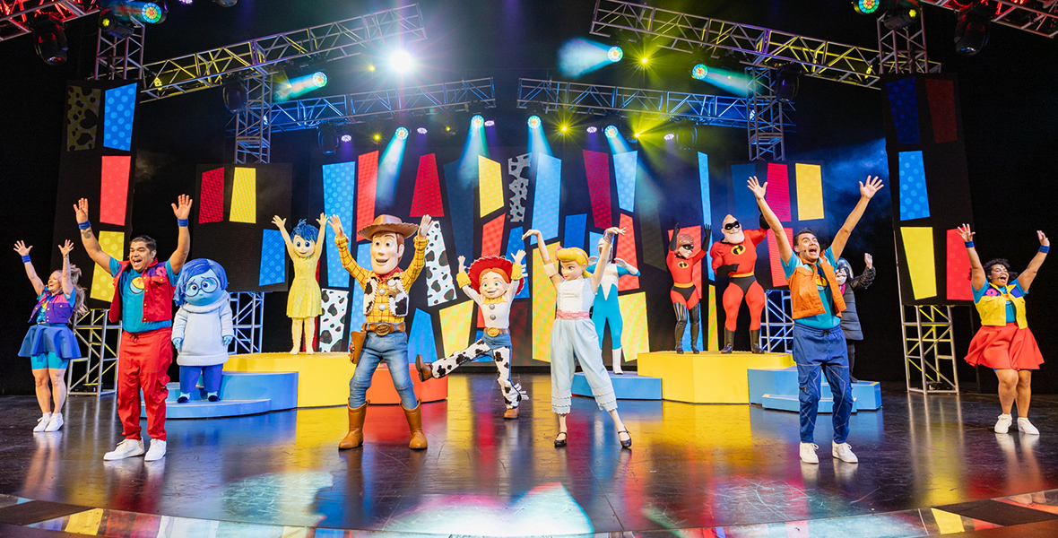 The stage comes to life during Pixar Pals Playtime Party. with an ensemble of beloved Pixar characters and Disney Live Entertainment dancers, bathed in the hues of iconic Pixar coloring: blues, yellows, and reds. From left to right, the stage’s lineup includes Sadness, Joy, Woody, Jessie, Bo Peep, Frozone, Mr. and Mrs. Incredible, and Edna Mode.