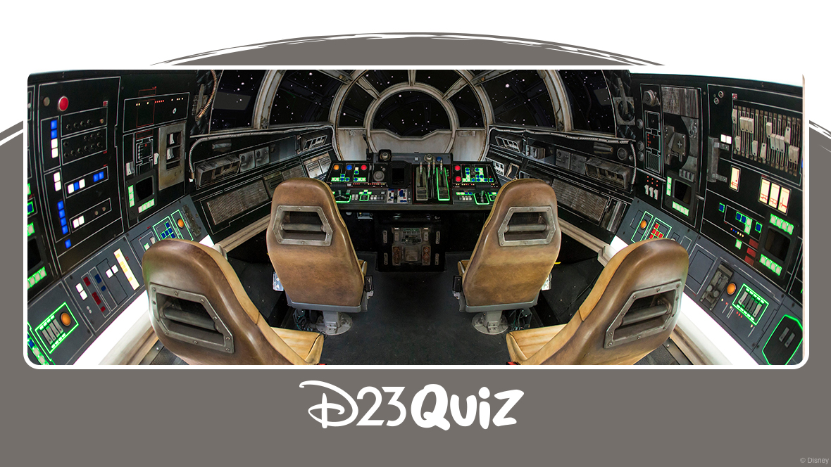 The inside of the Millennium Falcon: Smugglers Run attraction is a faithful recreation of the iconic Star Wars ship, featuring black walls adorned with switches and buttons, and a main view screen surrounded by seats in a semi-circle arrangement. The leather seats are weathered, and neon strips surround some of the buttons.
