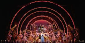 Photograph of the cast on stage performing the “Be Our Guest” musical number.