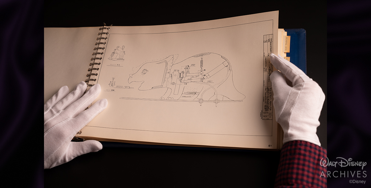 The Magic Skyway Maintenance Manual is opened to display the design and inner workings of one of the prehistoric dinosaurs; designed by WED Enterprises (Walt Disney Imagineering).