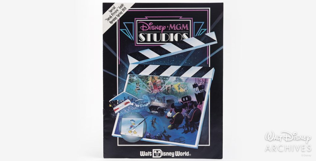 The preview guide is primarily a black booklet, with the pink and white Disney-MGM Studios logo in the center of the cover. The main image on the cover is a clapboard with concept art of the theme park.