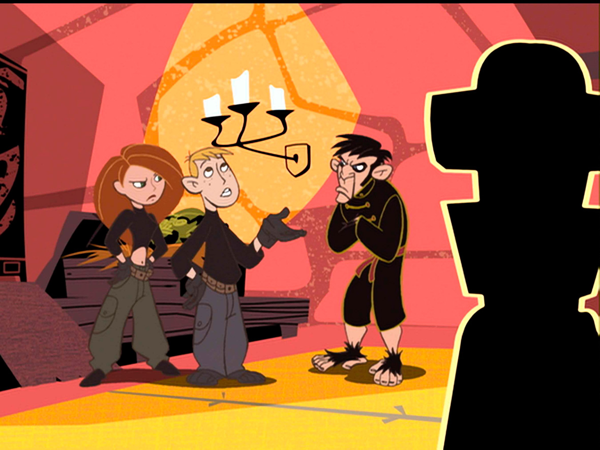 Lord Monkey Fist, from Kim Possible, dressed in an all-black  traditional martial arts outfit looks unamused at Kim and Ron while crossing his arms.
