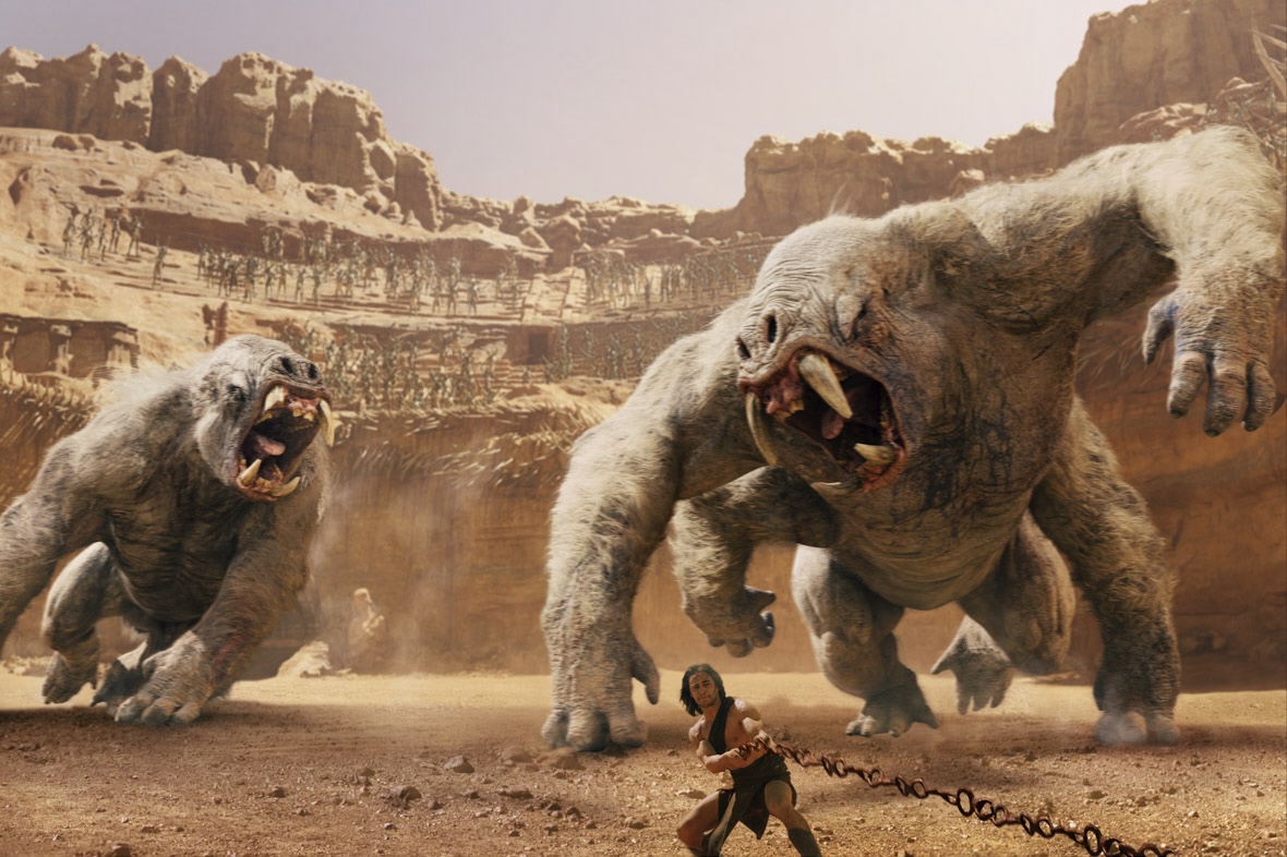 From John Carter, two massive White Apes are in the middle of a coliseum carved from rocks in Mars and running toward John Carter who is pulling on a massive metal chain.
