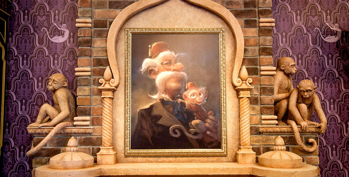 A painting above a stone fireplace with Albert the Monkey who is hugging Lord Henry. A stone monkey statue is to the left of the painting while to the right are two stone statues with one monkey standing behind a sitting monkey.
