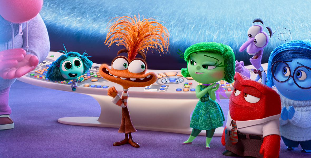 In a scene from Inside Out 2, from left to right, Joy (voiced by Amy Poehler), Embarrassment (voiced by Paul Walter), Envy (voiced by Ayo Edebiri), Anxiety (voiced by Maya Hawke), Disgust (voiced by Liza Lapira), Anger (voiced by Lewis Black), Fear (voiced by Tony Hale), and Sadness (voiced by Phyllis Smith) are standing behind the cream Headquarters console. Anxiety stands at the center of the group, nervously glancing toward Disgust, Anger, Fear, and Sadness, who are observing Anxiety with curiosity.
