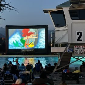 At D23’s 35th anniversary screening of The Little Mermaid, Ariel and Flounder are seen on the film screen as fans watch at the Hansen Dam Aquatic Center.
