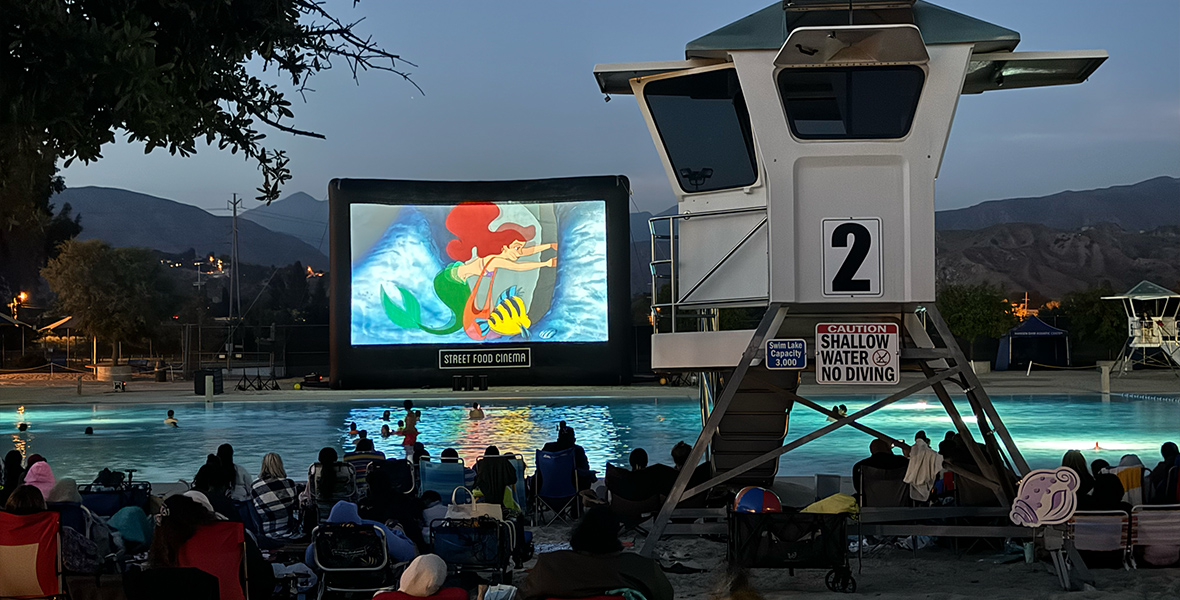 At D23’s 35th anniversary screening of The Little Mermaid, Ariel and Flounder are seen on the film screen as fans watch at the Hansen Dam Aquatic Center.