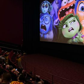 The Inside Out 2 logo appears on the screen as D23 Gold Member fans are in their movie theater seats, waiting for their early screening to begin.
