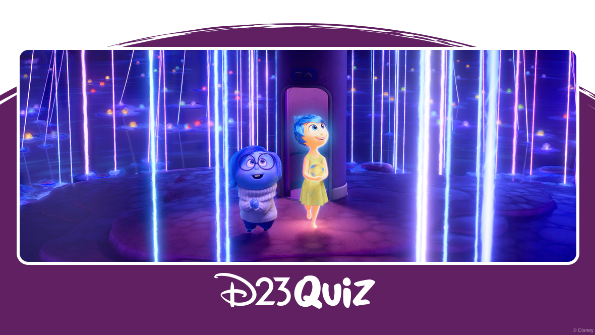 In a scene from Inside Out 2, Sadness (voiced by Phyllis Smith) and Joy (voiced by Amy Poehler) are standing on a dark blue island, surrounded by dark blue water. Neon-colored spheres with neon rays extending upward are scattered around the island and in the water. Behind Joy is a purple cylinder with a door-sized opening at its base. Both Joy and Sadness look upwards, amazed.
