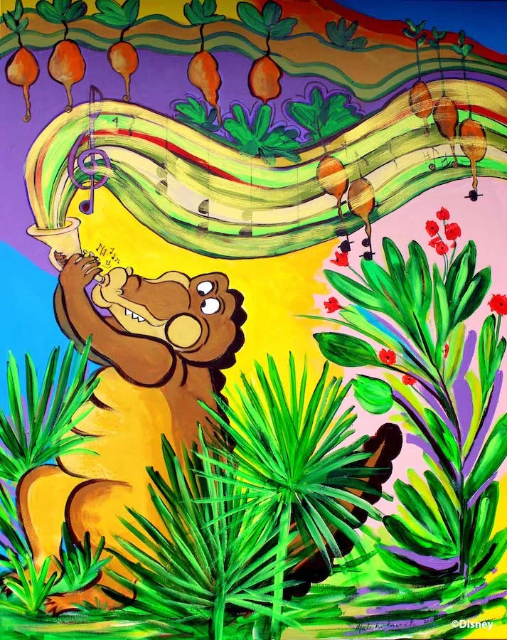 A part of the bright and colorful mural on the outside of Tiana’s Bayou Adventure at Walt Disney World. The mural depicts Louis the alligator playing the trumpet amongst a bright, green garden. Music notes come out of his trumpet, on a staff colored in with reds, greens, and yellow. The musical notation surrounds a variety of turnips in the air above him.