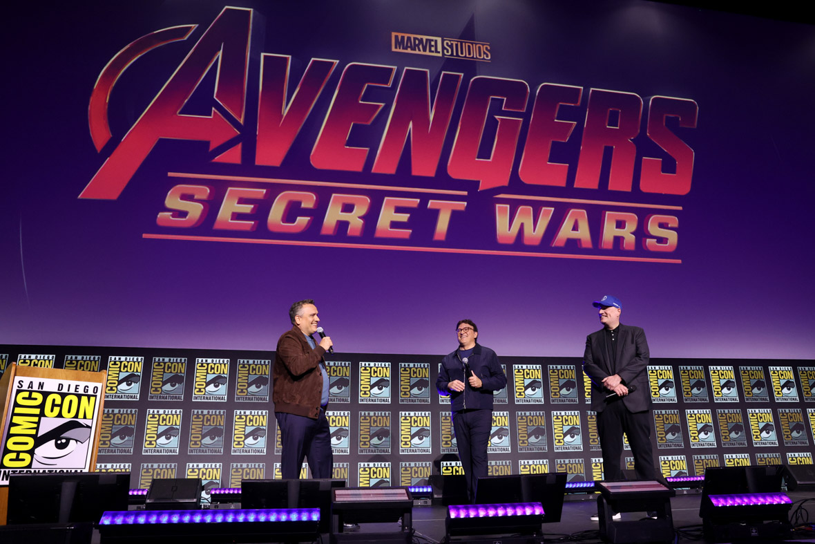 Joe Russo, Anthony Russo, and Kevin Feige appear onstage at San Diego Comic-Con. Behind them, the brand-new Avengers: Secret War logo is displayed on a giant screen.