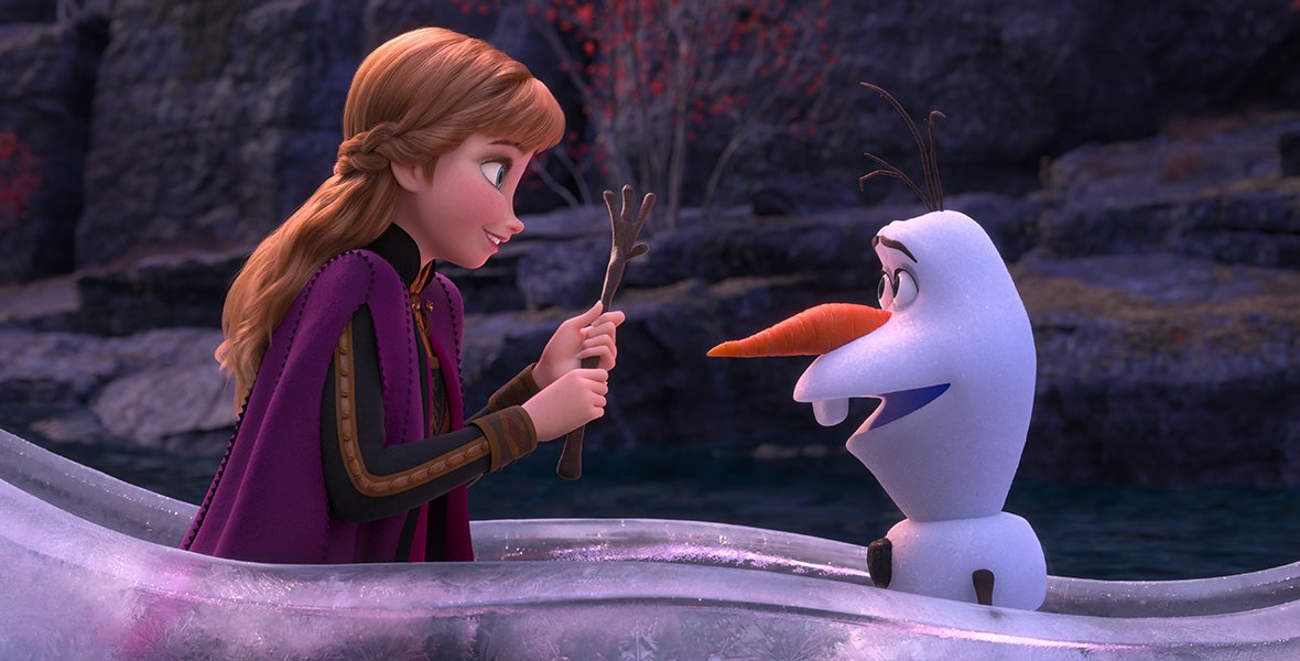 In an image from Frozen 2, Anna (left) faces Olaf (right) and holds one of his arms. They are in an ice boat.