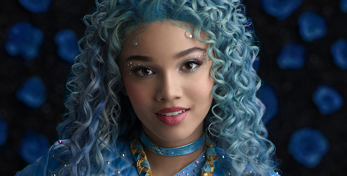 In a promotional image for Disney Channel’s Descendants: The Rise of Red, Chloe, played by Malia Baker, has curly blue hair and wears an all-blue ensemble.