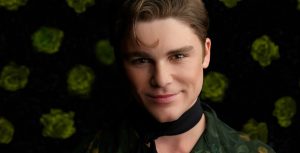 In a promotional image for Disney Channel’s Descendants: The Rise of Red, Morgie, played by Peter Lindell, wears a green and gold shirt and a black scarf.