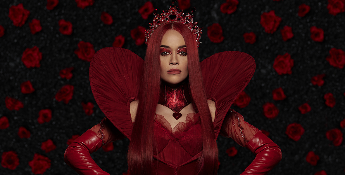 In a promotional image for Disney Channel’s Descendants: The Rise of Red, the Queen of hearts, played by Rita Ora, has straight crimson hair. She is wearing a crimson tiara, crimson leather gloves, and a crimson ballgown with heart-shaped sleeves. 