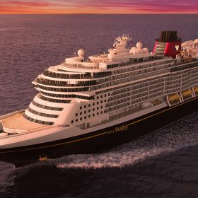 The image depicts a Disney cruise ship sailing on the ocean. The ship is marked with the name "Disney Destiny" on its side and features the iconic red and black funnels adorned with the Disney logo. The ship is shown from an elevated perspective, highlighting its multiple decks, numerous windows, and lifeboats along the side. The background shows a serene sea under a beautifully colored sunset sky.